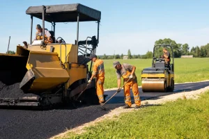 A road resurfacing crew at work on a country road in morning sun