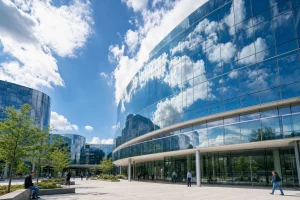 A glass administration building reflecting the sky