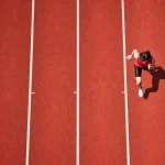 A running track from above, one athlete, every other lane empty