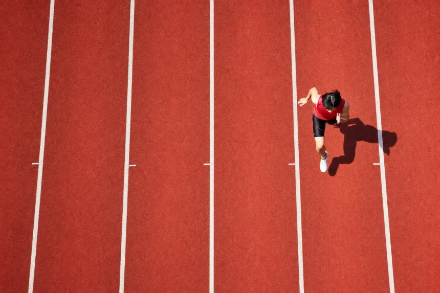 A running track from above, one athlete, every other lane empty