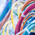 Densely bundled fibre-optic patch cables in many colours, in close-up