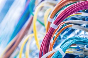 Densely bundled fibre-optic patch cables in many colours, in close-up