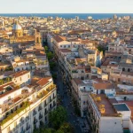 Aerial view of a dense Mediterranean city block grid at golden hour