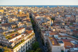 Aerial view of a dense Mediterranean city block grid at golden hour