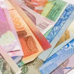 Macro of overlapping banknotes from many countries in strong colour