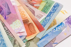 Macro of overlapping banknotes from many countries in strong colour