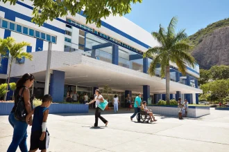 A public hospital exterior in strong sun with a blue and white tiled facade