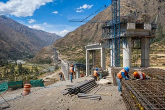A highway bridge under construction across a wide Andean valley