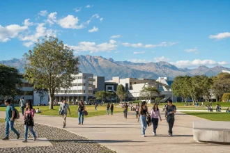 A large public university campus in bright daylight with mountains beyond