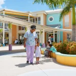 A Caribbean hospital exterior in full sun with palm trees