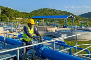 A new water treatment works with blue pipework and concrete tanks in morning light