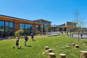 A contemporary school building in timber and glass with playing fields