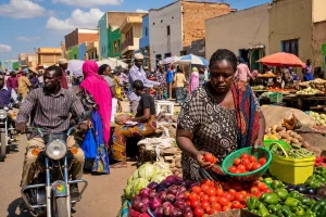 A busy East African district market street at midday